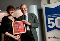Professor M. Wynn Thomas, chairman of the Welsh Books Council, presents the award to Lynwen Rees Jones, director CES