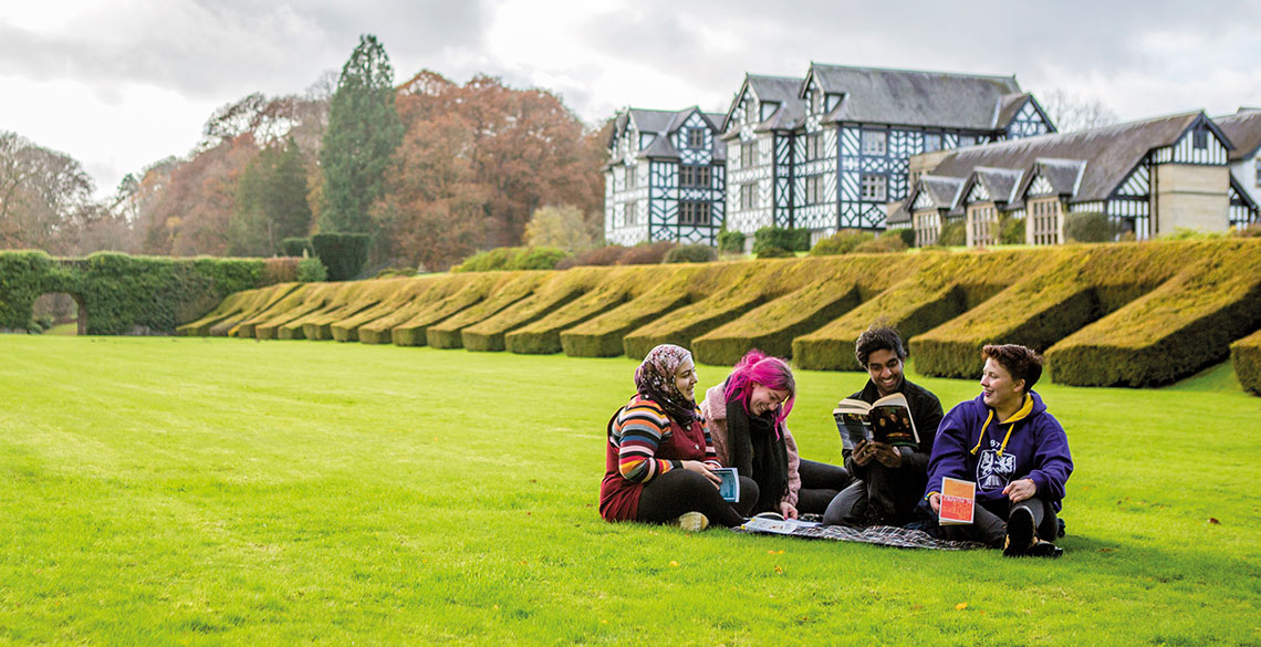 Myfyrwyr yn eistedd ar y lawnt yng Ngregynog