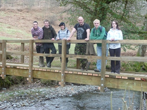 Toby Ballard, Matthew Pinnock, Samantha Wright, Gareth Salvidant, Gwydion Ifan a Sarah Fielder yn sefyll ar y bont a adeiladodd y grŵp