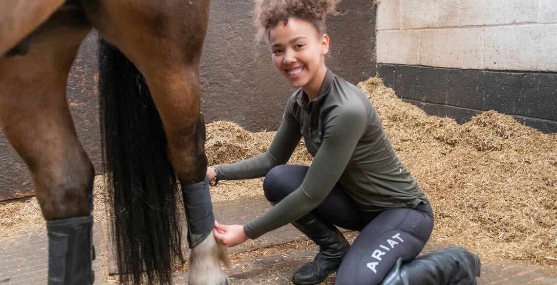 Female student attending to her horse in the Lluest Equine Centre. 