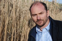 Dr Iain Donnison gyda Miscanthus yn y cefndir