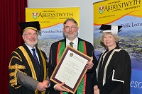 Dr Glyn Rowlands BSc PhD, Is-Lywydd, yr Athro Douglas Kell CBE, Cymrawd a’r Athro April McMahon, Is-Ganghellor