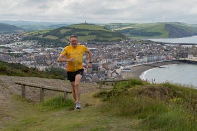 Yr Athro John Grattan yn rhedeg lan Rhiw Craig Laes yn Aberystwyth yn ystod un o’i sesiynau hyfforddi.