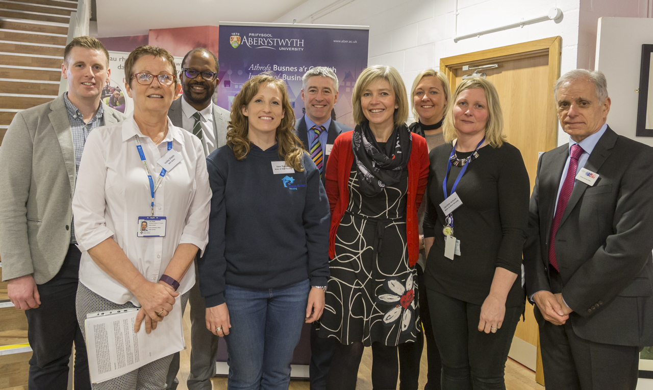 Rhes flaen, o'r chwith i'r dde: Mrs Lesley Oldale (NHS Cymru), Kate Thomas (Wales & West Housing), Yr Athro Jo Crotty (Prifysgol Aberystwyth), Caroline Jackson (Wales & West Housing) a Yr Athro Nicholas Perdikis (Prifysgol Aberystwyth) Rhes gefn, o'r chwith i'r dde: Rob Bowen (Prifysgol Aberystwyth), Dr Ola Olusanya (Prifysgol Aberystwyth), Barry Rees (Cyngor Sir Ceredigion) a Carly Hodson (Wales & West Housing)