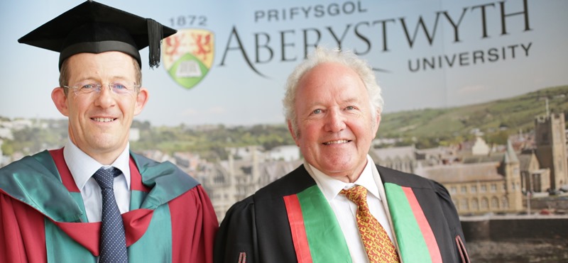 Cymrawd er Anrhydedd Prifysgol Aberystwyth Heini Gruffudd(dde)a Dr Bleddyn Huws, Uwch Ddarlithydd yn Adran y Gymraeg ac Astudiaethau Celtaidd.