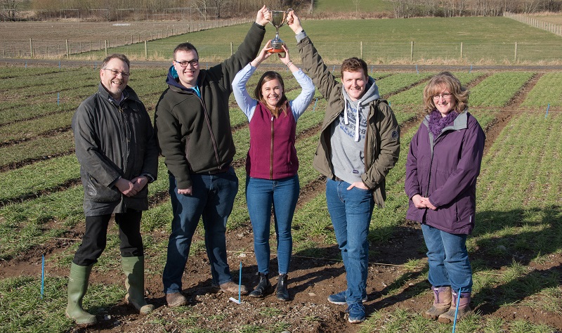 Aelodau tîm buddugol IBERS Cwpan Agronomeg NIAB 2017 James Bradley, Anna Crockford a David Casebow gyda Dr Iwan Owen a Dr Irene Griffiths, Darlithwyr Amaeth IBERS; ar lieiniau treialon gwenith a barlys y myfyrwyr yng Ngogerddan.