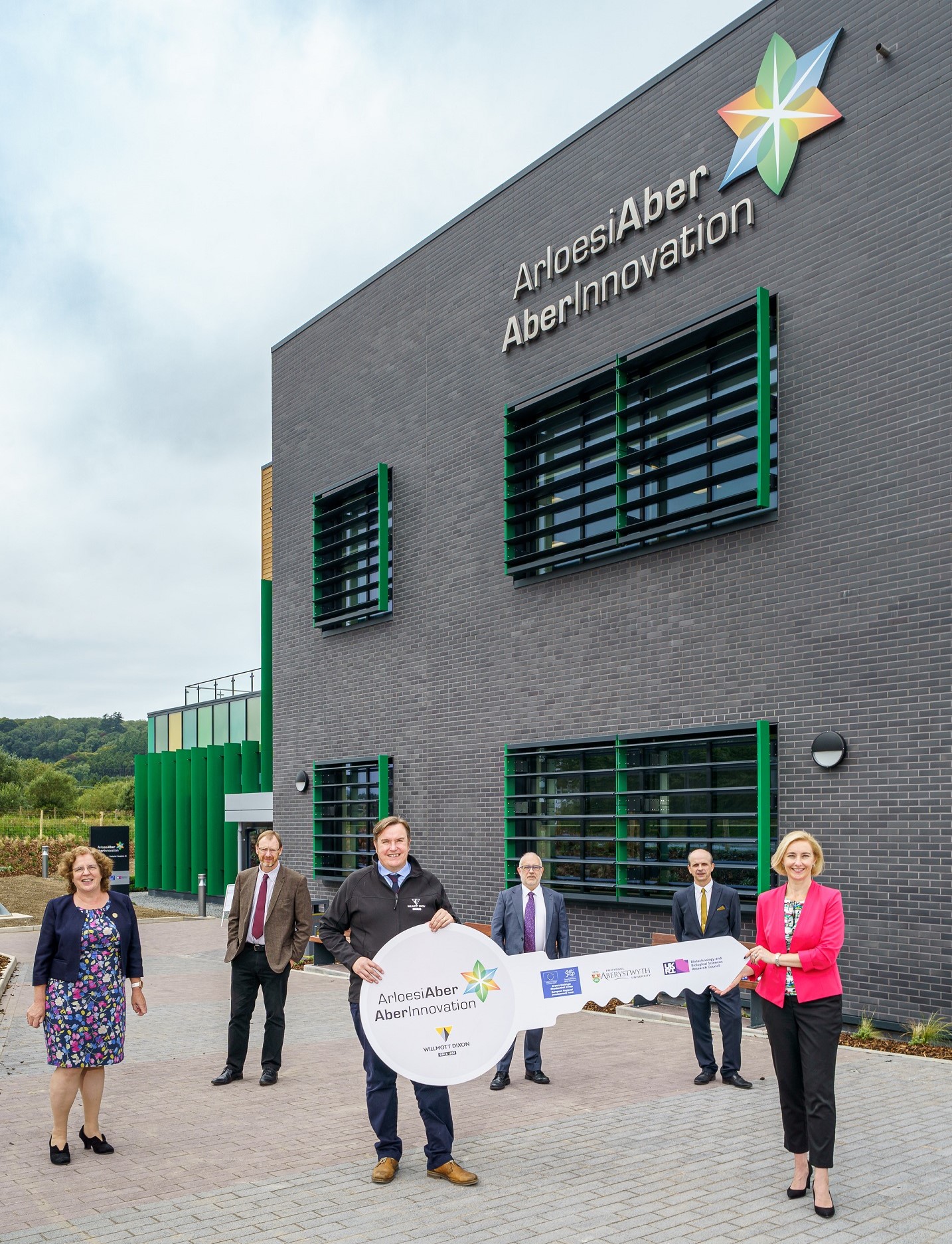 (Chwith i’r dde): Yr Athro Elizabeth Treasure, Is-Ganghellor Prifysgol Aberystwyth; Peter Ryland, Prif Swyddog Gweithredol, Swyddfa Cyllid Ewropeaidd Cymru; Darren Hancock, Rheolwr Gweithrediadau, Willmott Dixon; Yr Athro Colin McInnes, Ddirprwy Is-Ganghellor Ymchwil, Cyfnewid Gwybodaeth ac Arloesi, Prifysgol Aberystwyth; John Collingwood, Uwch Reolwr Prosiect (Cwsmer), Prifysgol Aberystwyth; Dr Rhian Hayward MBE, Prifweithredwr ArloesiAber