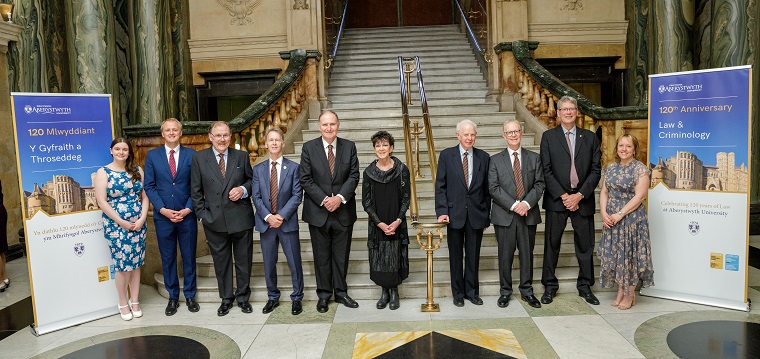 O’r chwith i’r dde: Lauren Marks, Llywydd Cymdeithas Cyn-fyfyrwyr PA; Ben Lake, AS Ceredigion; Y Gwir Anrhydeddus Elfyn Llwyd, Dirprwy Ganghellor PA; Dr Emyr Roberts, Cadeirydd Cyngor PA; Y Gwir Anrhydeddus Arglwydd Lloyd Jones; Meri Huws, aelod o Gyngor PA; Y Gwir Anrhydeddus Arglwydd Thomas o Gwmgïedd, Canghellor PA, Yr Athro Emyr Lewis, Pennaeth Adran y Gyfraith a Throseddeg PA; Yr Athro Tim Woods, Dirprwy Is-Ganghellor PA; a'r Athro Anwen Jones Dirprwy Is-Ganghellor PA