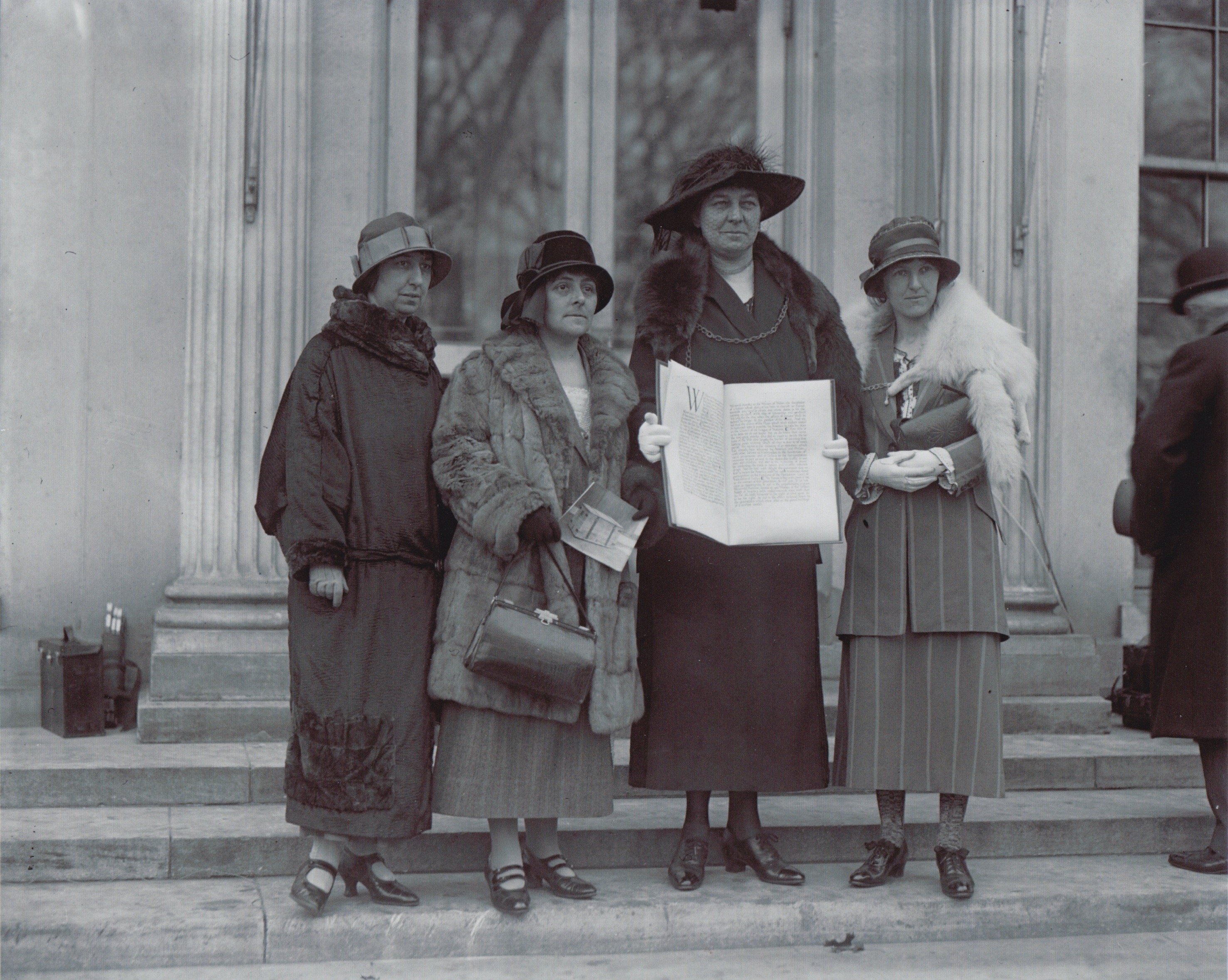 Arweinydd y ddirprwyaeth aeth â’r ddeiseb heddwch hanesyddol i’r Unol Daleithiau yn 1924 oedd Annie Hughes-Griffiths a welir yma yn dal yr apêl y tu allan i’r Tŷ Gwyn yn Washington DC gyda Gladys Thomas, Mary Ellis ac Elined Prys. Llun: Canolfan Materion Rhyngwladol Cymru.