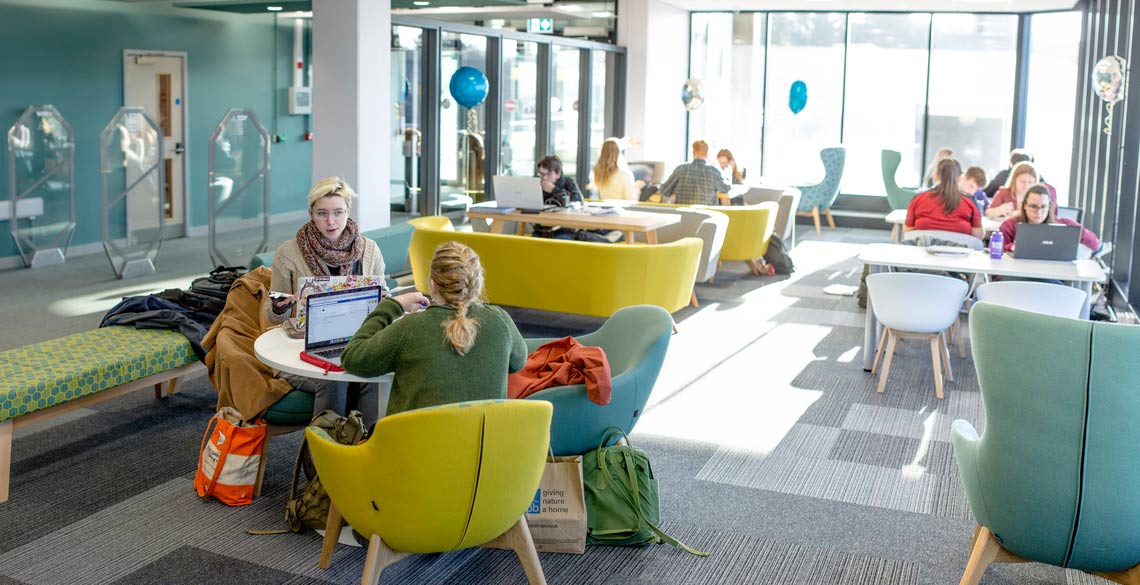 Students sat at a table in Hugh Owen Library