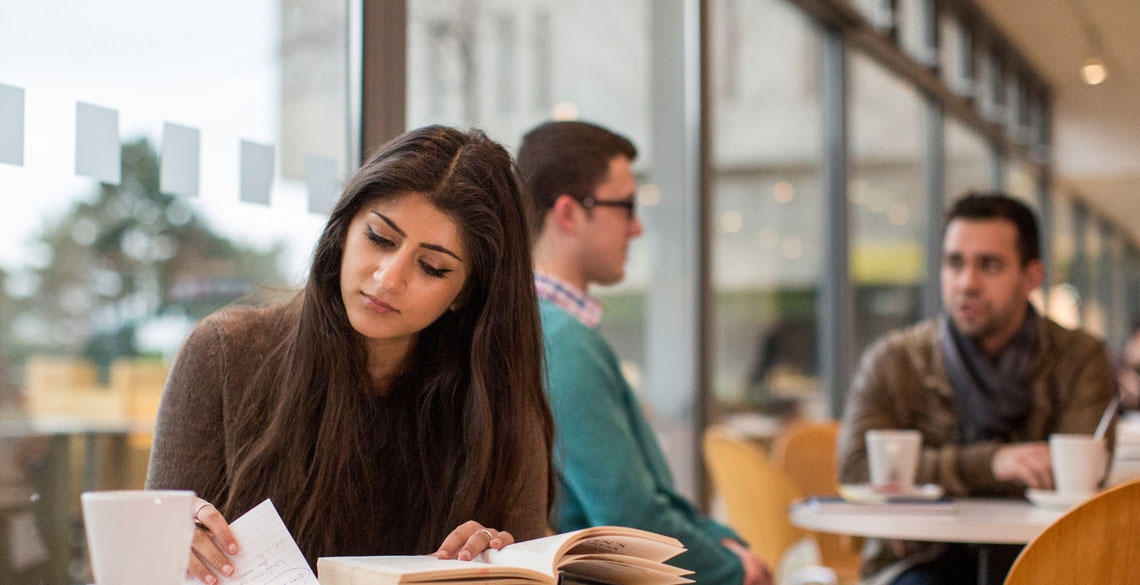 Student sat in cafe reading/studying