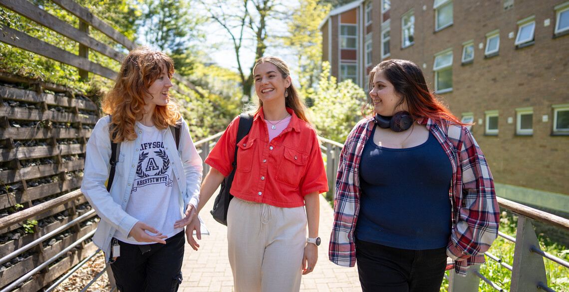 Three girls walking to their lecture