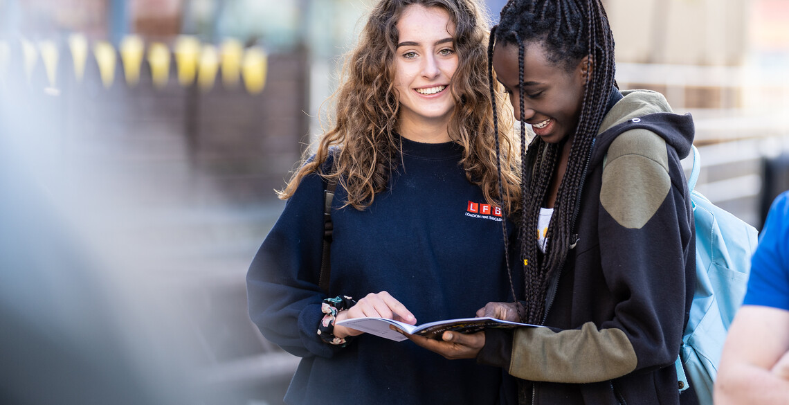 Two girls reading a booklet