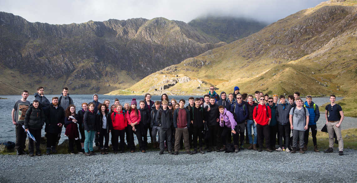image of students on a field trip with mountains and lake in the background