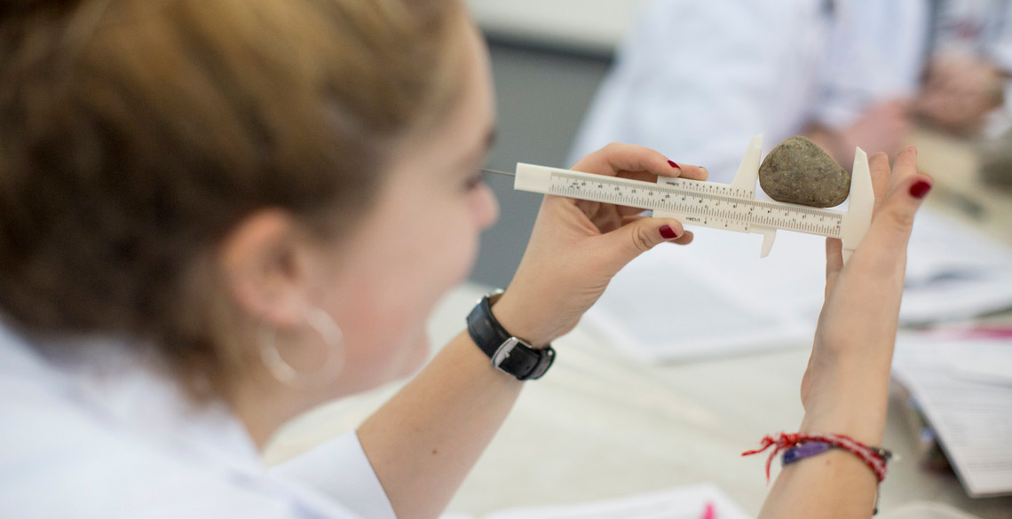 Student measuring a stone using Vernier Calipers 