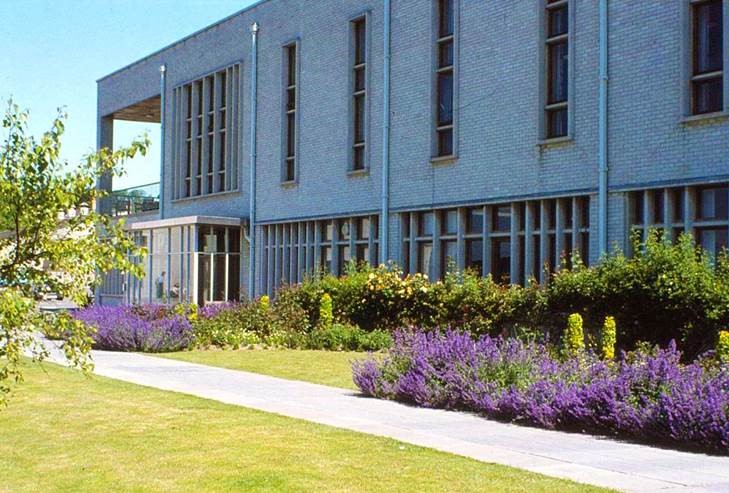 Colour photograph of the front of Thomas Parry Library of College Librarianship Wales, Llanbadarn Campus, Aberystwyth, with Summer shrubs and flowers in bloom.