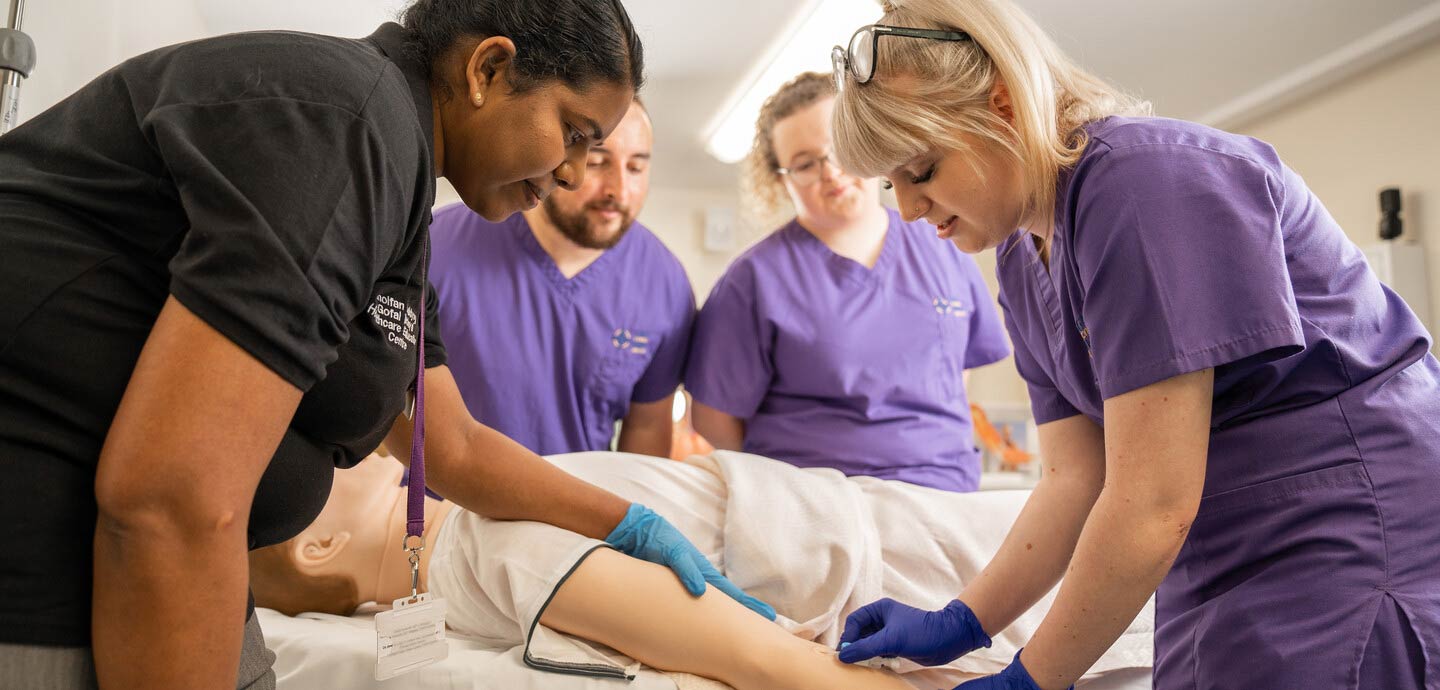 Student nurses practising on a manikin