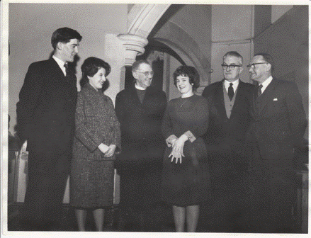 A group of three students, a clergyman, and two members of staff, one of whom is Dr. Thomas Parry (Principal, second right), the other is T. Maelgwyn Davies (Registrar, far right). The student on the far left is Arwel Ellis Owen (Student President). Estimated date: 1965-66.