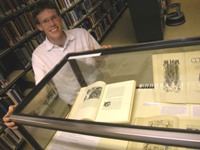 Dermot Ryan with some of the University's rare books and manuscripts