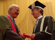 Lord Chief Justice Judge (left) receives a commemorative scroll from Professor Noel Lloyd.