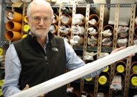 Dr Henry Lamb holding a metre long section of core taken from Lake Suigetsu. The cores are stored at 4oC in a large cold store at Aberystwyth University.