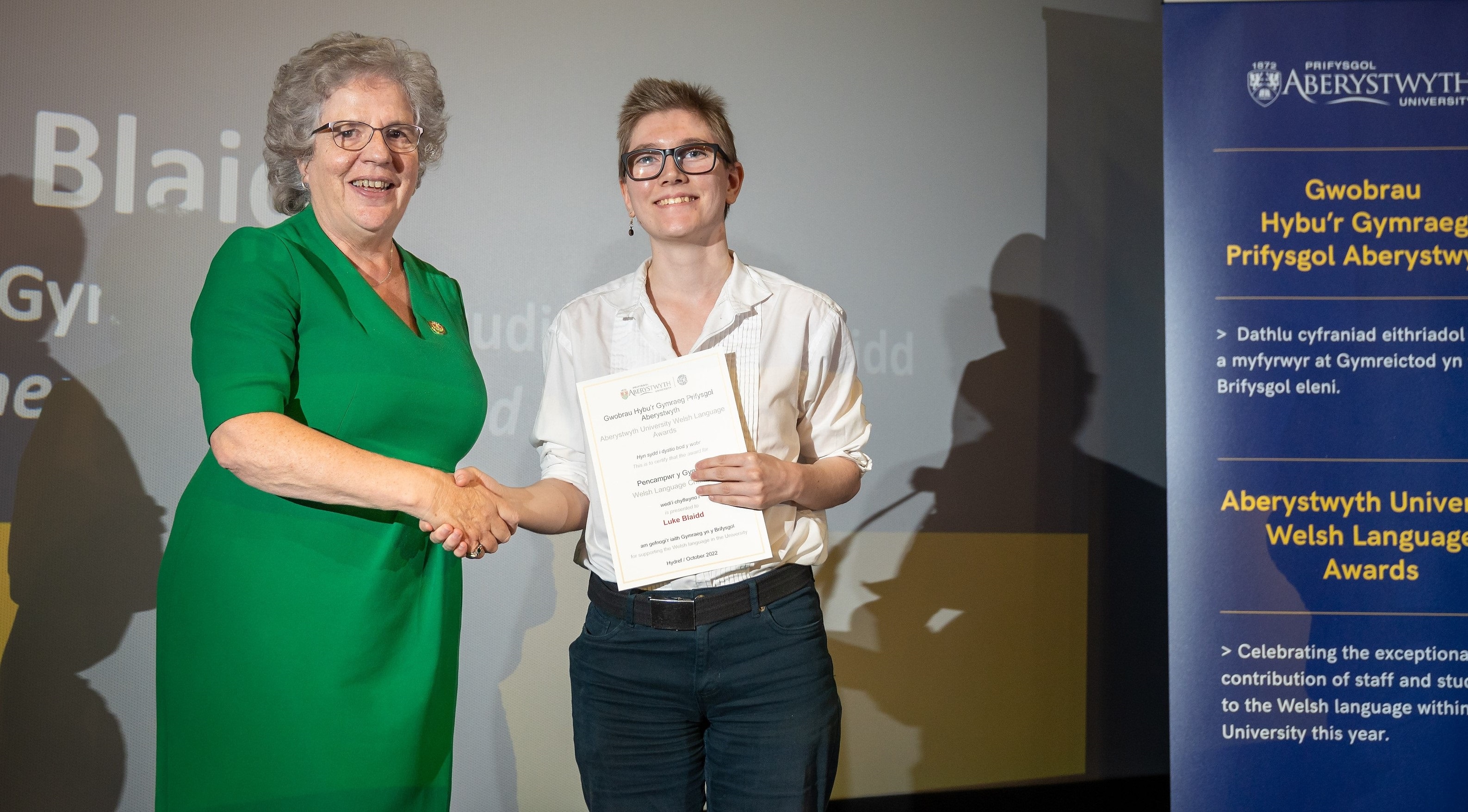 Undergraduate student Luke Blaidd receives the award for Welsh Language Champion from Professor Elizabeth Treasure, Vice-Chancellor Aberystwyth University. Born in Stockport and raised in north Manchester, Luke is the first member of his family to speak Welsh.