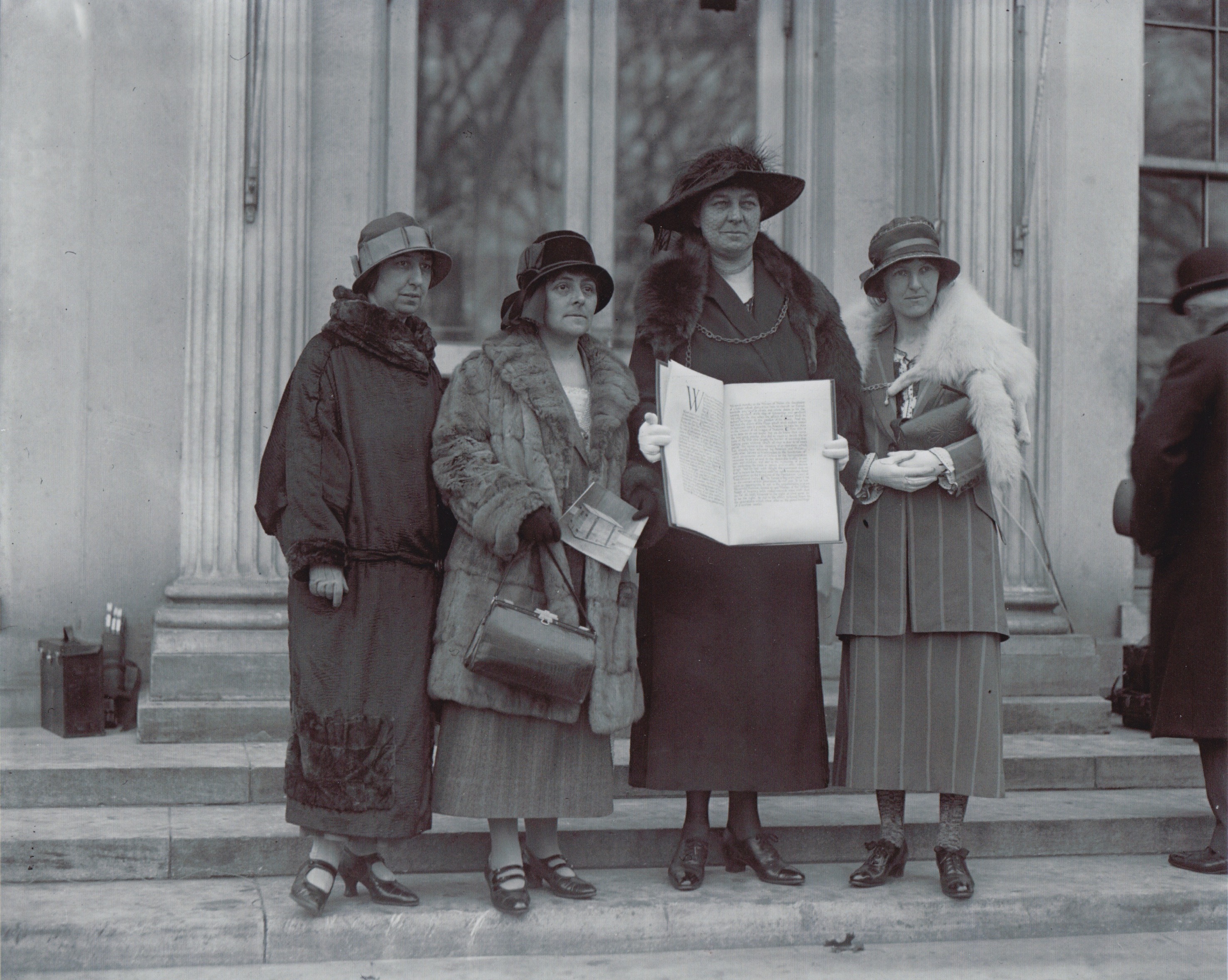 The delegation of women who took the historic peace petition to the United States of America in 1924 was led by Annie Hughes-Griffiths who is pictured holding the appeal on the steps of the White House in Washington DC with (L-R) Gladys Thomas, Mary Ellis and Elined Prys). Photo credit: Welsh Centre for International Affairs.