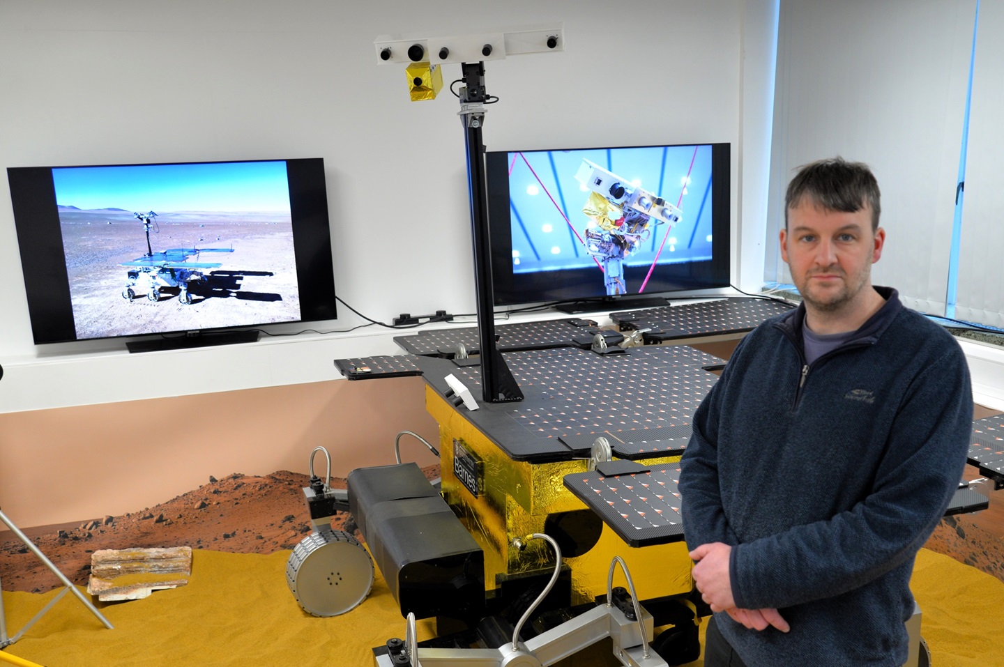 Dr Matt Gunn, Principal Investigator on Enfys, the new infrared spectrometer being developed for the ExoMars mission, with a full size model of the Rosalind Frankin rover at Aberystwyth University. Credit: Aberystwyth University