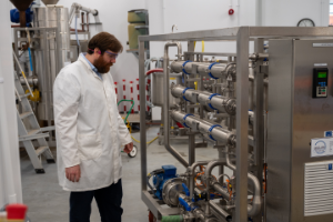 Alun Hughes, Postdoctoral Research Scientist at IBERS and who worked on the research, pictured with the biorefinery equipment that was used