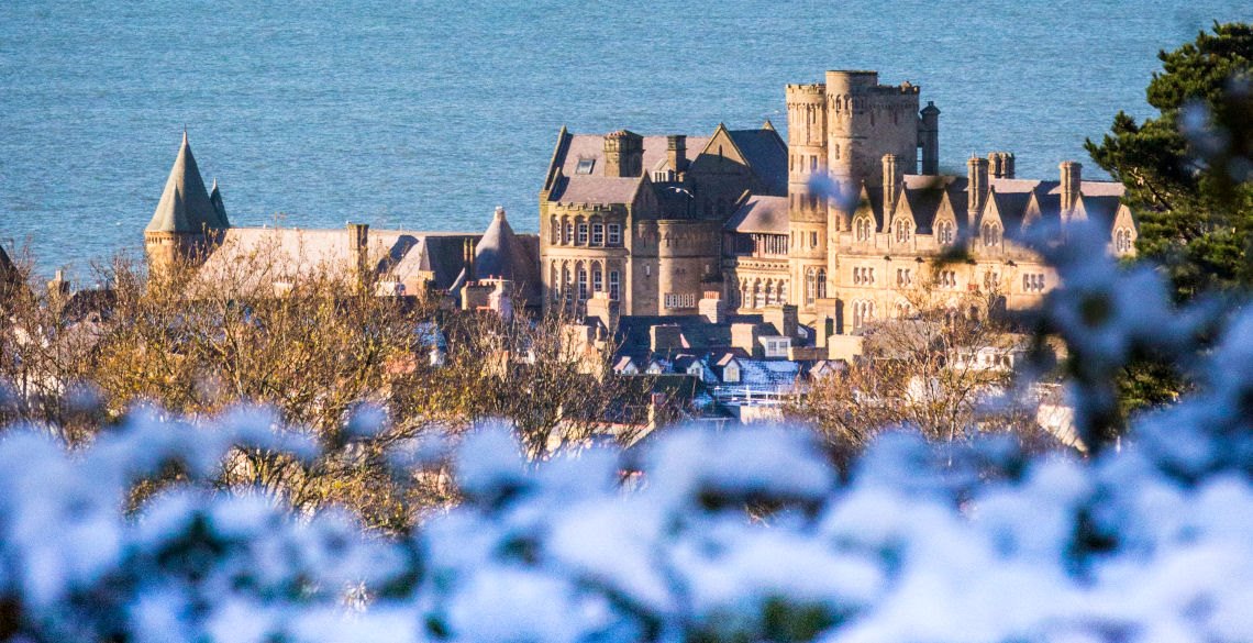 Snow fall on the Old College and Aberystwyth North Promenade.