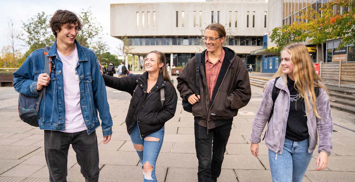 Students on campus walking in front of the Hugh Owen Library, Penglais Campus, Aberystwyth University. 