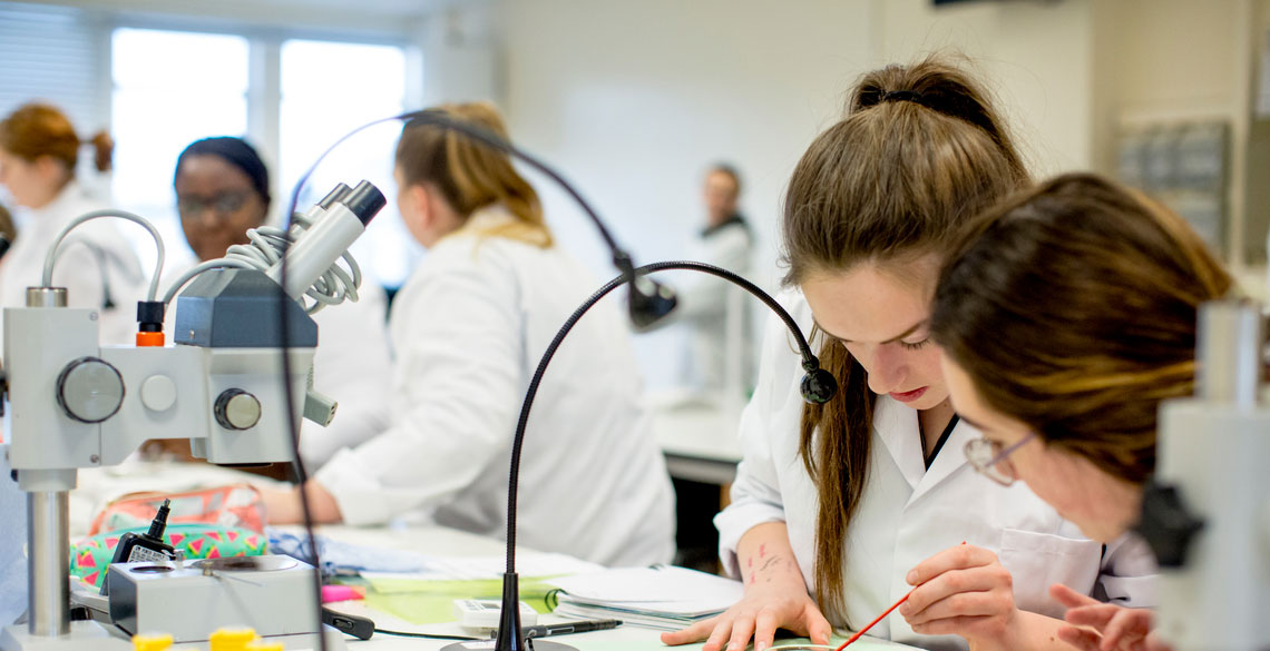 Students conducting tests: students in white coats: lab equipment