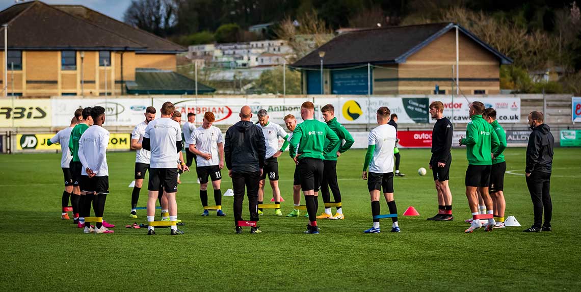Aberystwyth Town Football Club players warm-up and talk tactics before a training session.