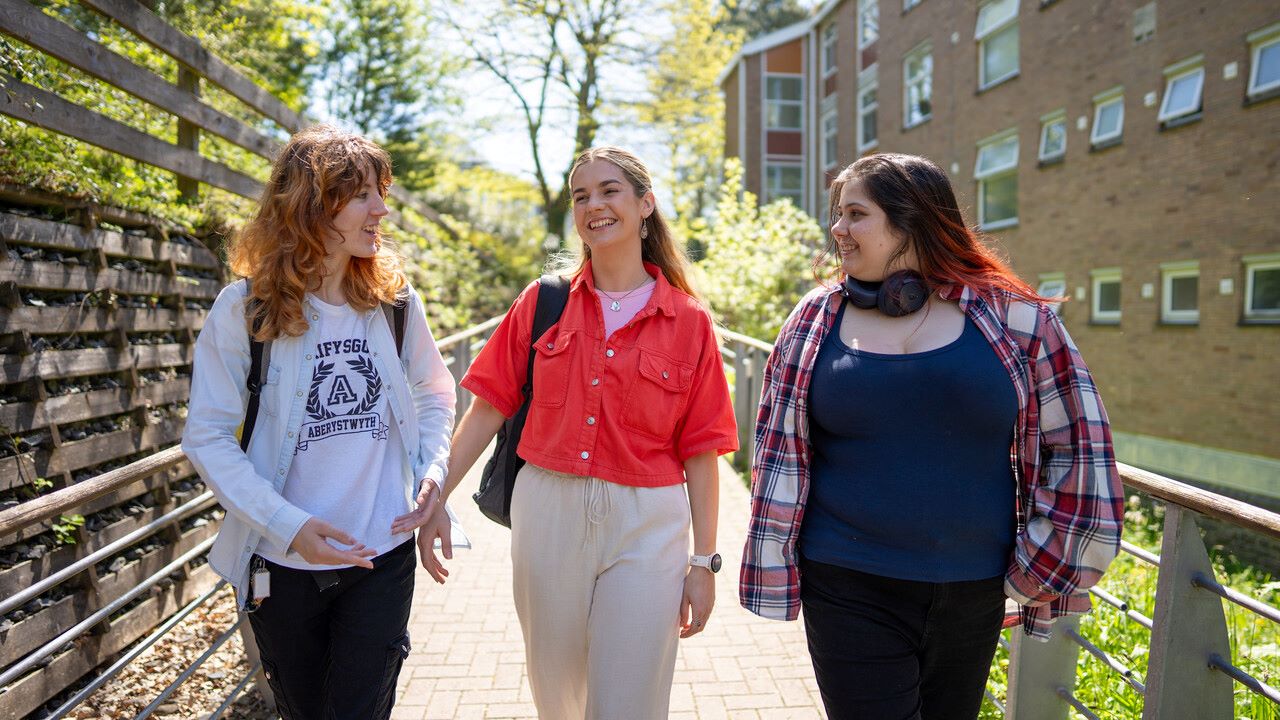 Three students walking on campu