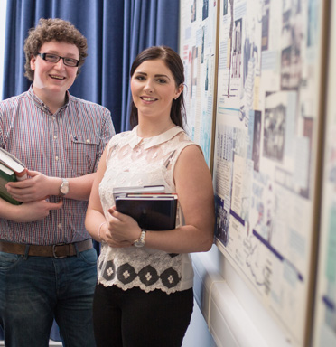 Photo of 2 students holding books